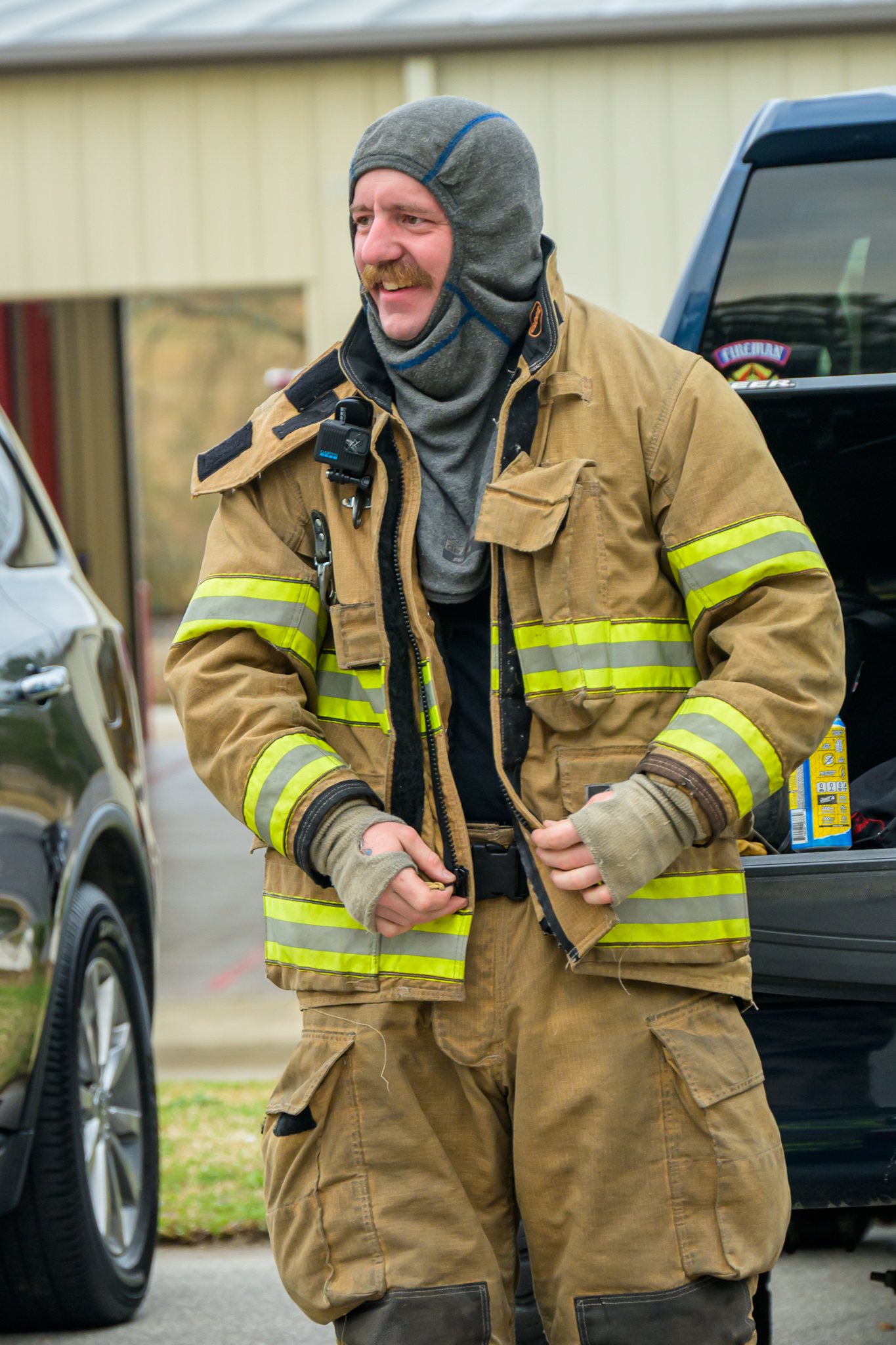 Firefighter zipping turnout coat during prep